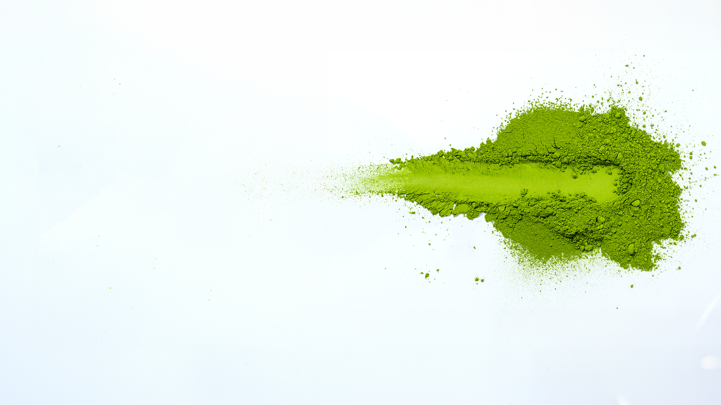 Vibrant green ceremonial grade matcha powder on white background showing the intense colour of premium Japanese matcha