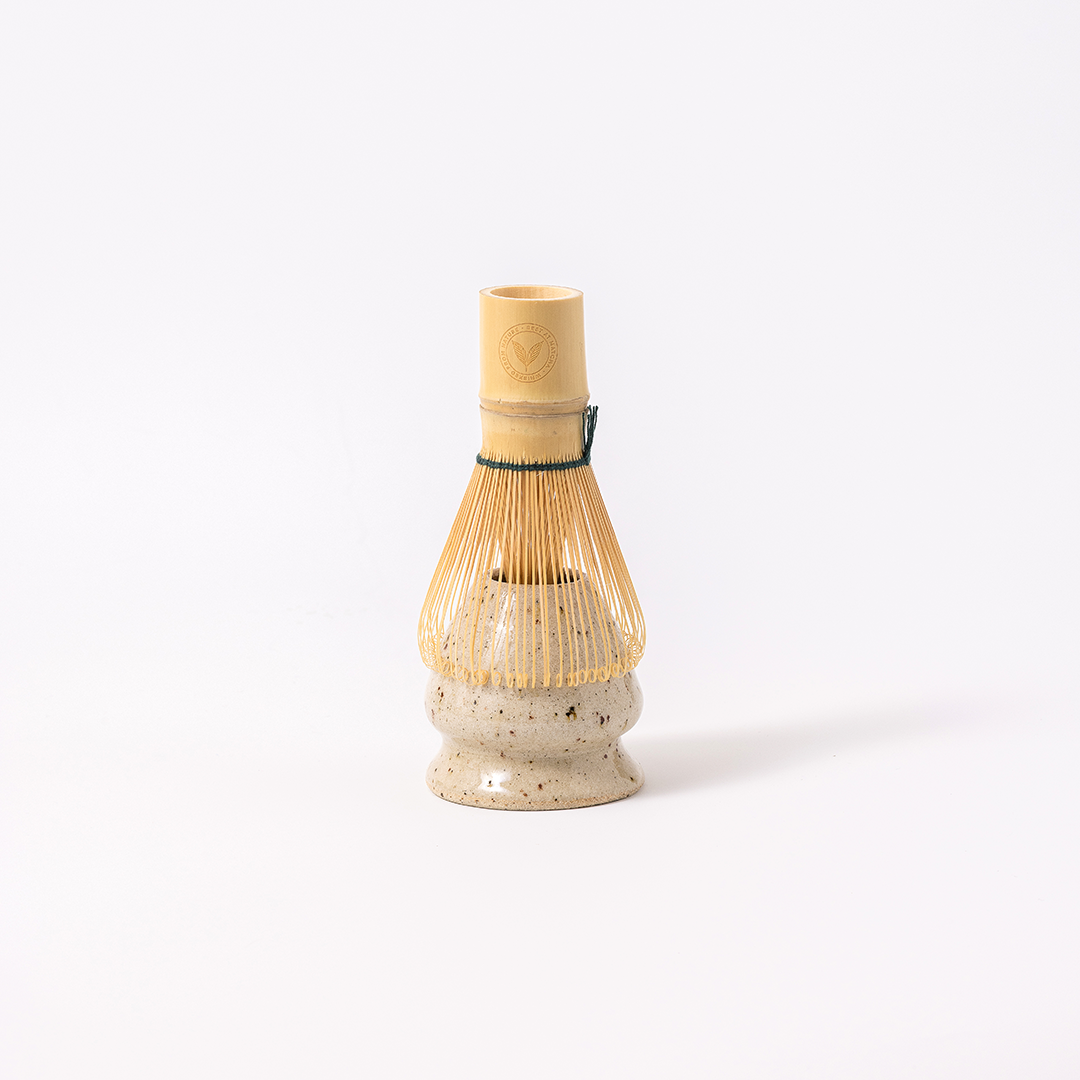 Best at Matcha bamboo chasen resting on Suna ceramic kusenaoshi whisk stand — traditional matcha whisk and stand set